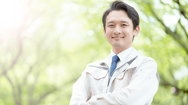 作業服の男性がほほ笑む様子